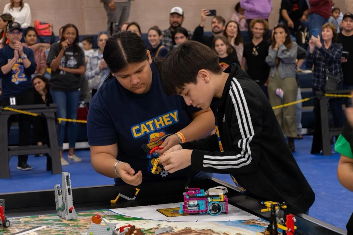 A FIRST LEGO League team building their robot at the competition table