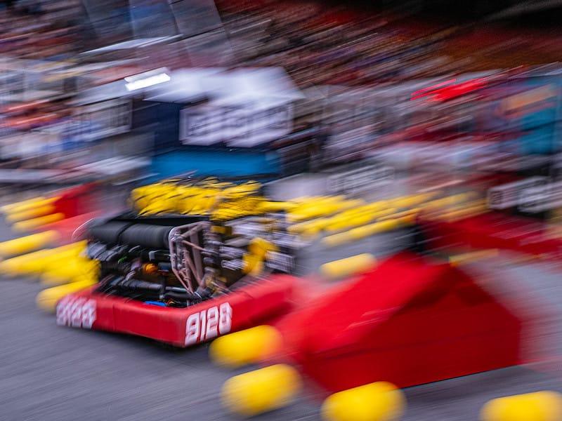 A FIRST Robotics Competition robot crossing the field, the arena blurred behind it