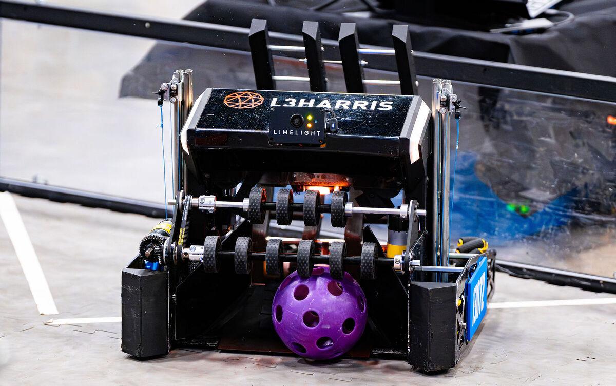 A sponsor-backed FIRST Tech Challenge robot holding a game piece
