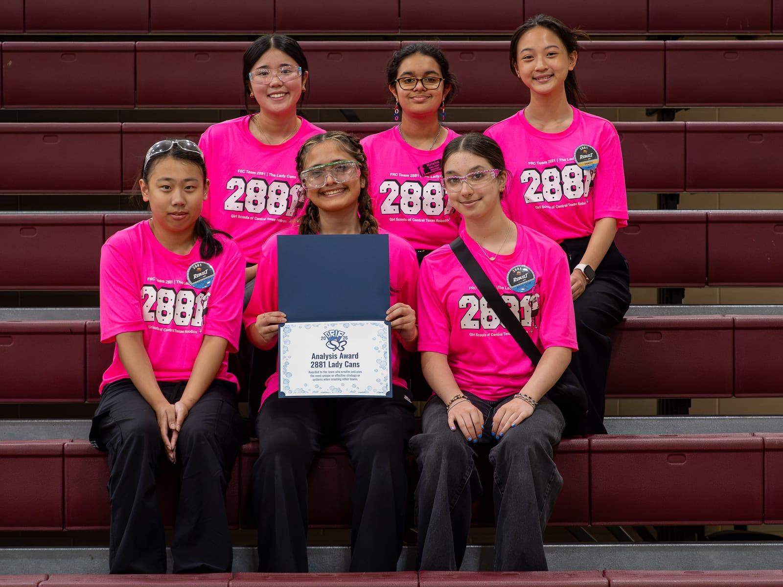 An all-girls FIRST Robotics Competition team with the award they won at a Texas off-season event