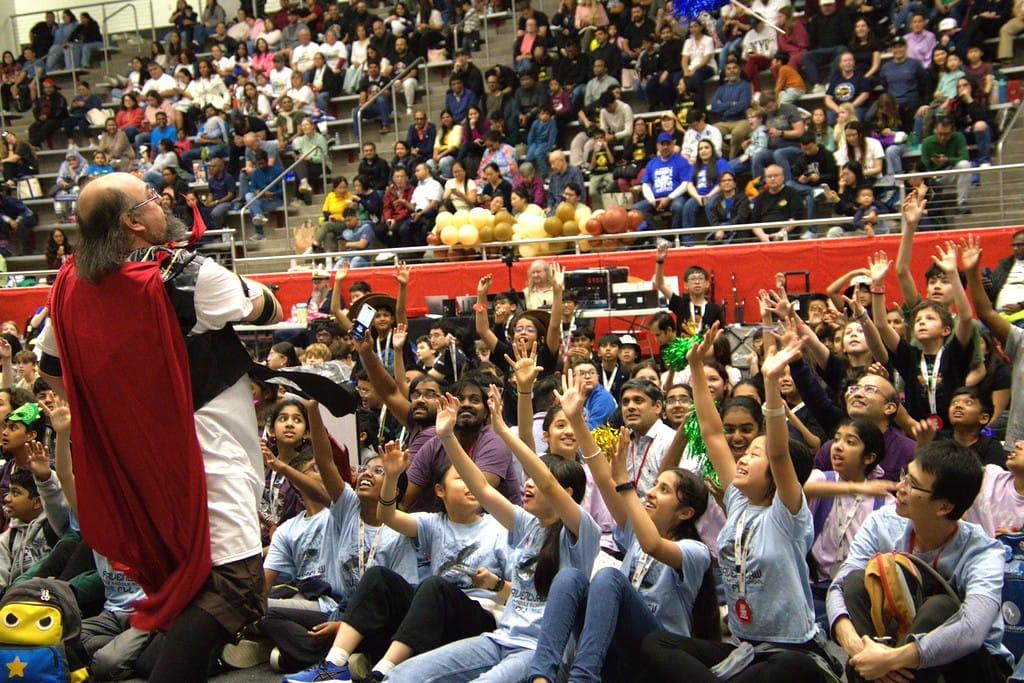 Students with their hands up cheering in the arena at the FIRST LEGO League Texas State Championship 2026